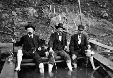 A crew of gentlemen dip their feet in thermal hot springs